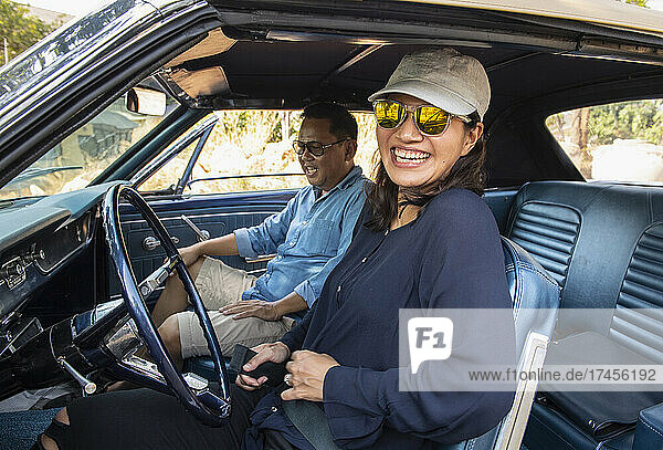Couple on a road trip with classic American muscle car in Thailand