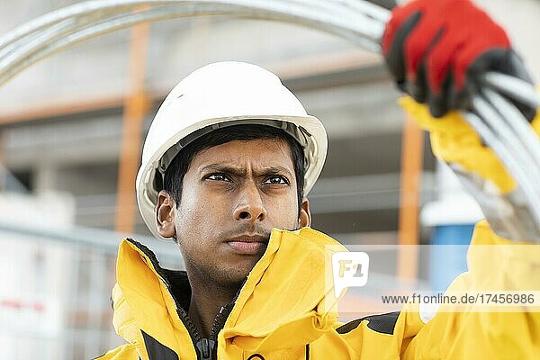 Young technician with helmet and yellow protective jacket working outside  Freiburg  Baden-Württemberg  Germany  Europe