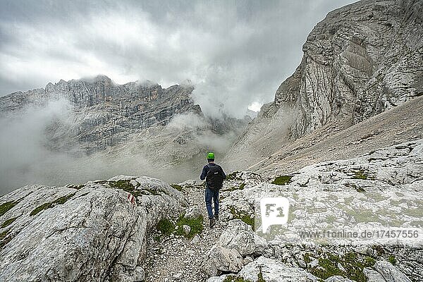 Wanderer  Bergsteiger auf einem Wanderweg zwischen felsigem wolkenverhangenen Gebirge am Forcella Sore de la Cengia  Sorapiss Umrundung  Dolomiten  Belluno  Italien  Europa