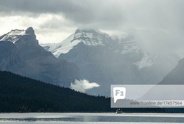 Boot auf dem Maligne Lake  dahinter Bergkette Queen Elizabeth Ranges mit dem Samson Peak  Wolkenhimmel  Jasper National Park  Rocky Mountains  Alberta  Kanada  Nordamerika