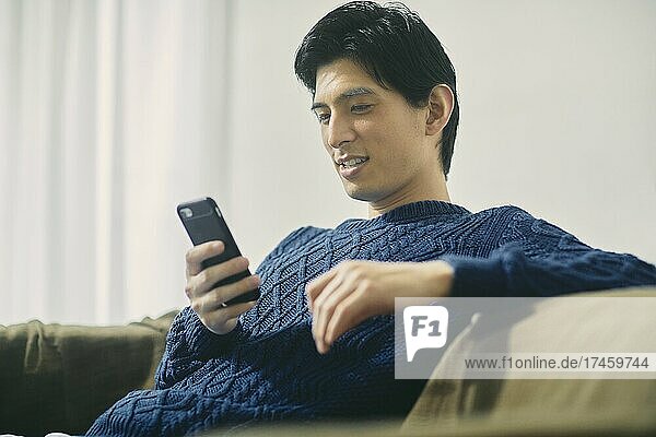 Japanese man relaxing on the sofa