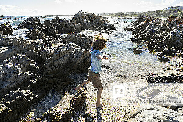Eight year old boy exploring a rocky beach