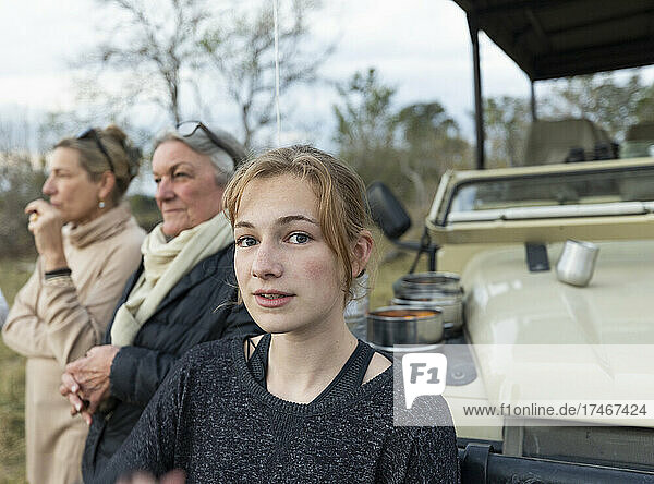 Three generations of women  a grandmother  mother and teenage girl by a safari jeep
