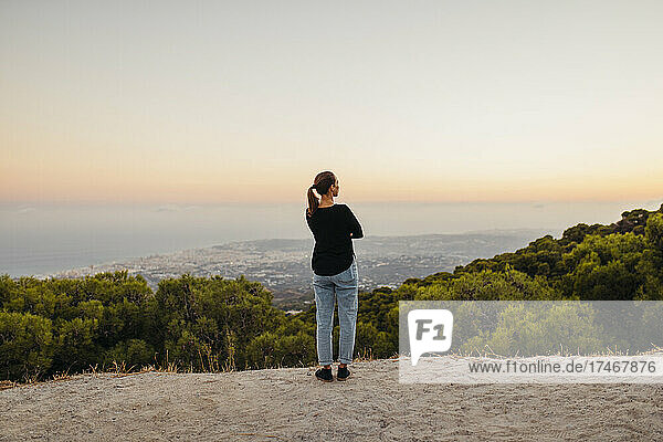 Woman looking at view while standing on mountain