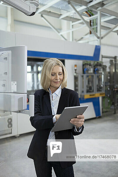Female professional working on digital tablet at factory