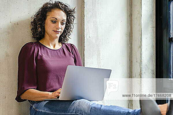 Unternehmerin nutzt Laptop während der Arbeit im Büro