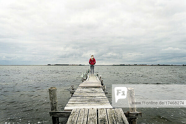 Woman looking at sea while standing on jetty