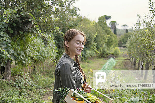 Smiling female farmer looking down in garden