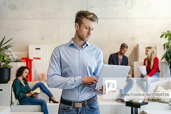 Businessman using laptop in coworking office