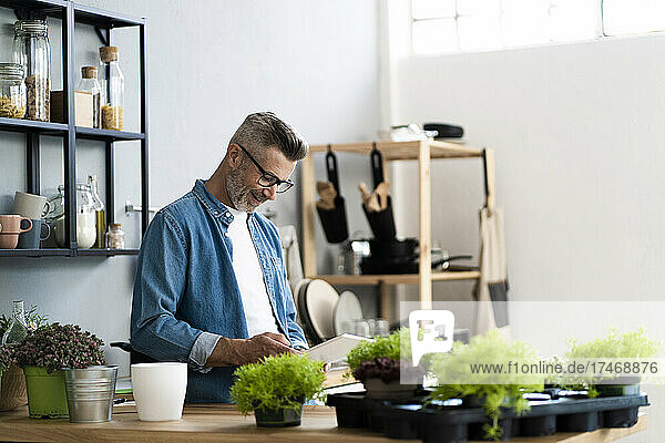 Man with eyeglasses using digital tablet in kitchen