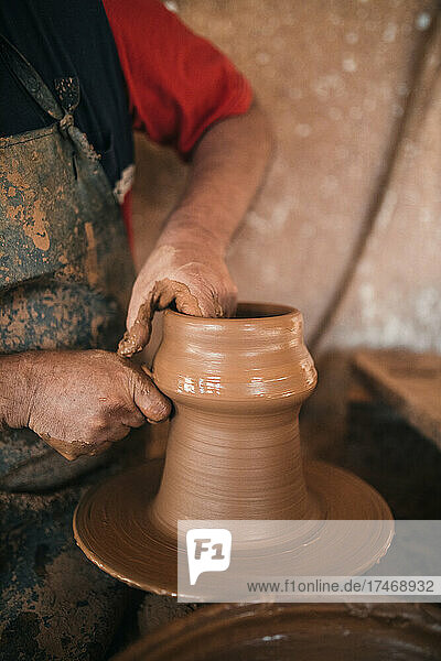 Potter making pot in workshop
