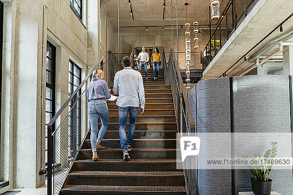 Coworkers walking on staircase in office