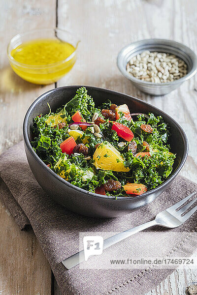 Bowl of kale salad with bell peppers and orange