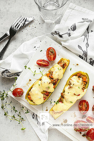 Stuffed zucchini with cherry tomatoes and cheese served on table
