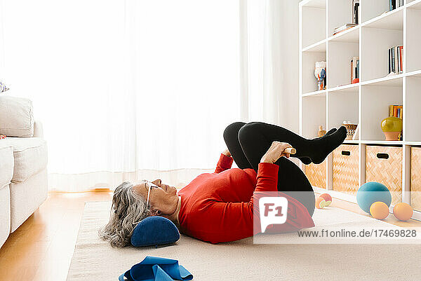 Woman exercising while lying down at home