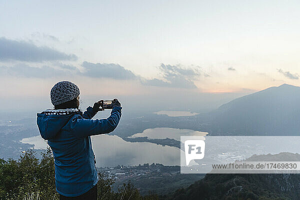 Wanderer fotografiert mit Smartphone am Berg