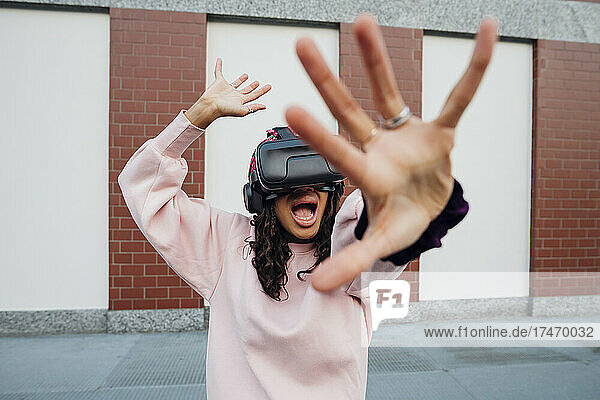 Woman screaming while using virtual reality headset on footpath
