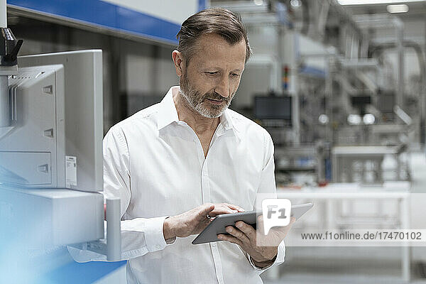 Male professional working on digital tablet in factory