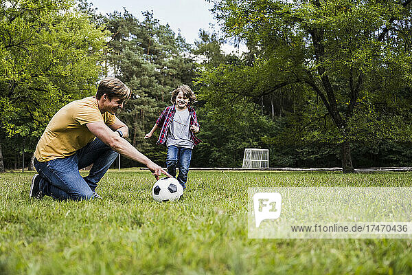 Family playing with soccer ball on grass