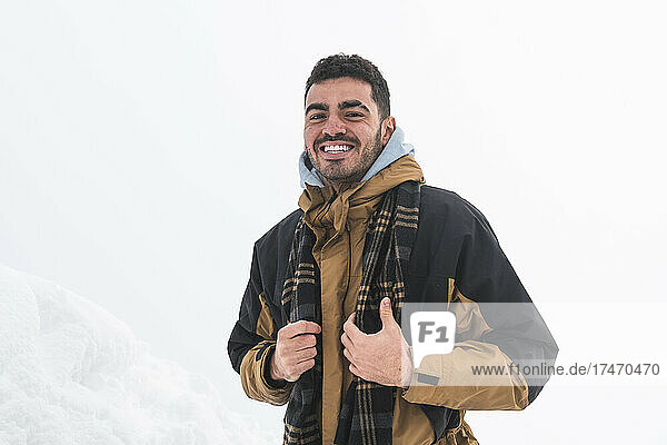 Smiling man hiking wearing warm clothes on snow