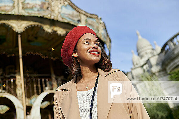 Lächelnde Frau mit Karussell und Basilique du Sacre Coeur im Hintergrund am Montmartre  Paris  Frankreich