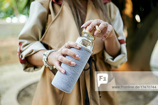 Woman holding reusable glass bottle