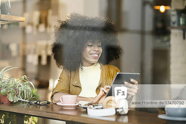 Woman using tablet PC at cafe window
