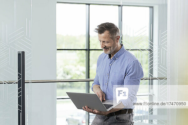 Mature male professional working on laptop in office