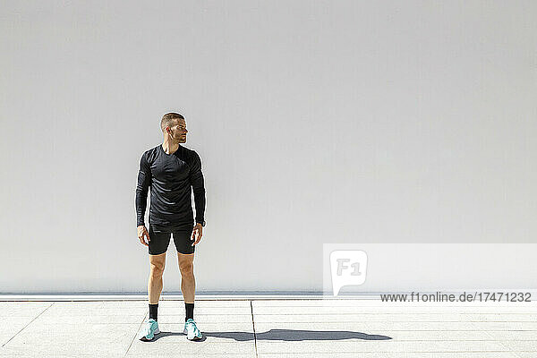 Sportsman standing in front of white wall