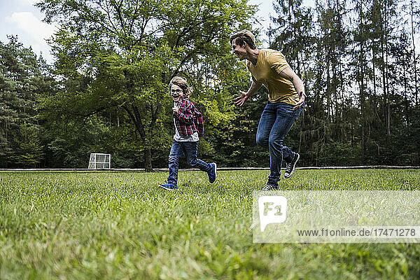 Happy son playing with father on grass