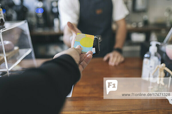 Customer paying through credit card in cafe