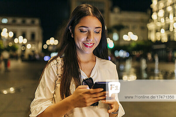 Woman using smart phone at street