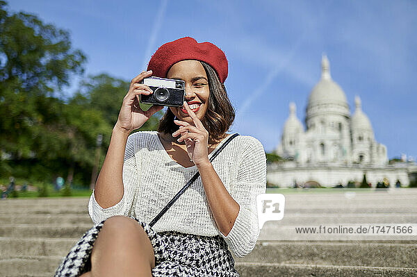 Female tourist photographing through camera at Basilique Du Sacre Coeur  Montmartre in Paris  France