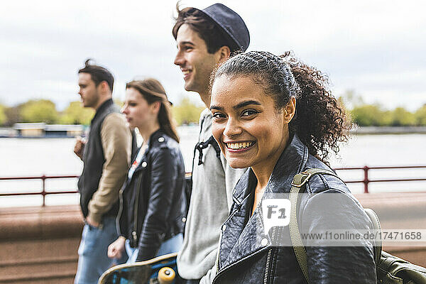 Young woman in leather jacket walking with friends