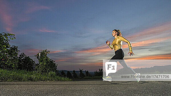 Young woman jogging alone at dusk