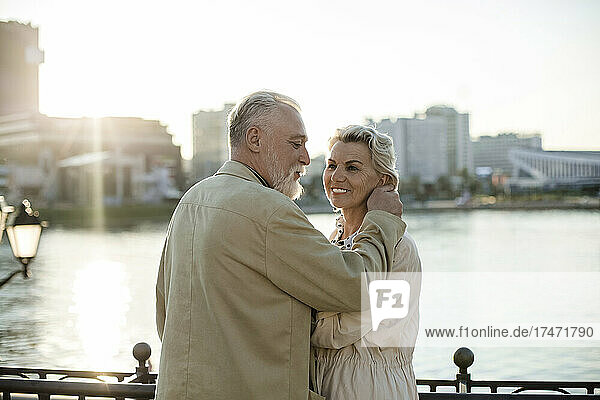 Smiling couple standing at embankment