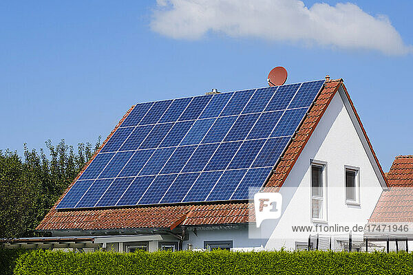 House with tiled roof covered with solar panels