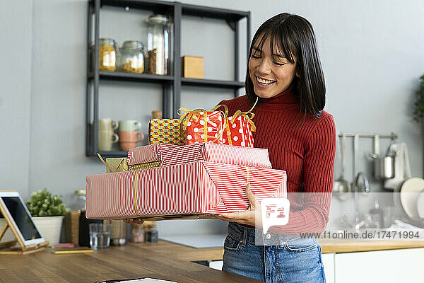 Happy businesswoman looking at gift boxes at home