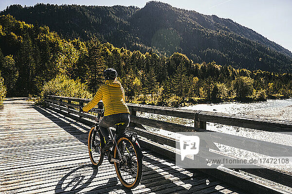 Woman riding mountain bike on bridge