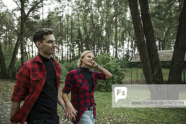 Couple holding hands while walking in park