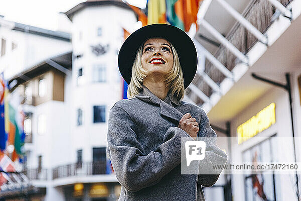 Smiling blond woman wearing coat and hat