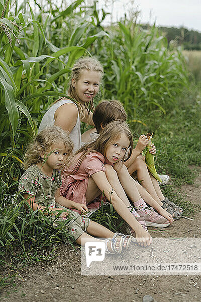 Family sitting together in corn field