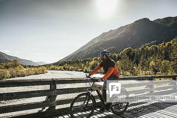 Man riding mountain bike on sunny day