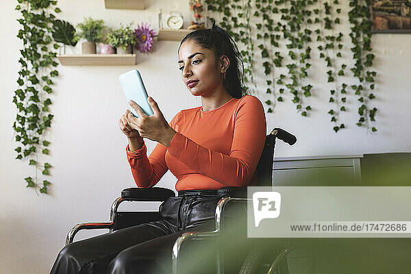 Woman with disability using smart phone on wheelchair
