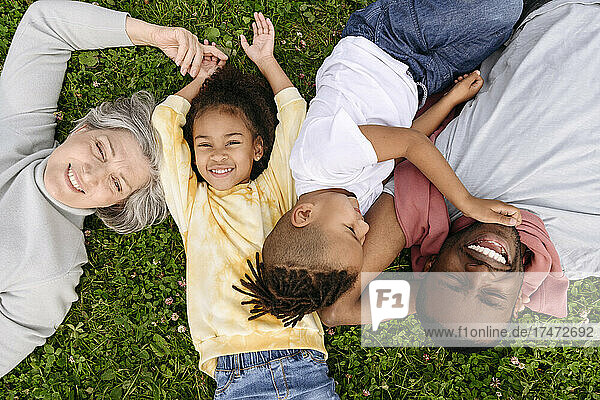Smiling family resting together on grass