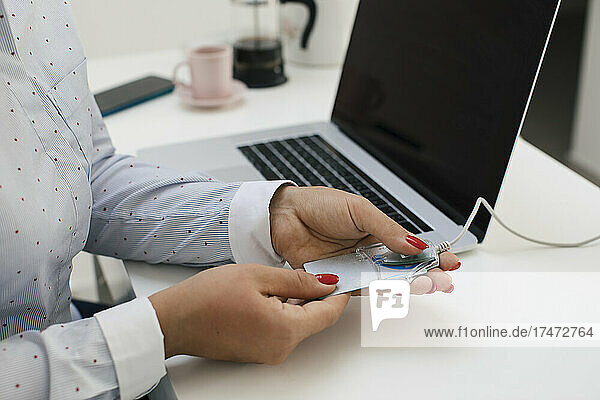 Female freelancer scanning credit card through reader while working at home office