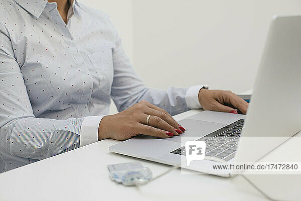 Businesswoman sitting at desk and working on laptop in home office
