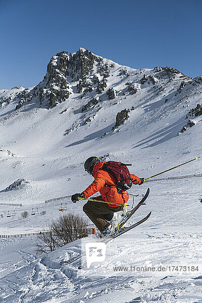 Tourist mit Rucksack beim Skifahren auf schneebedecktem Berg