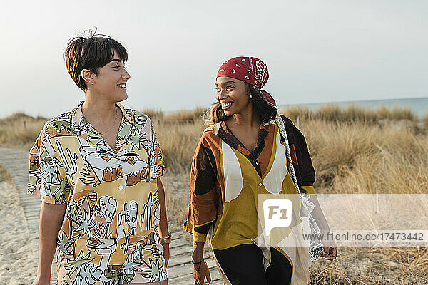 Smiling lesbian couple walking together at beach