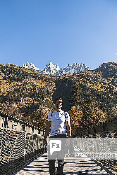 Hiker walking on footbridge in front of French Alps on sunny day  Chamonix  France